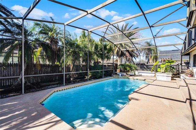 view of pool with a patio area and glass enclosure