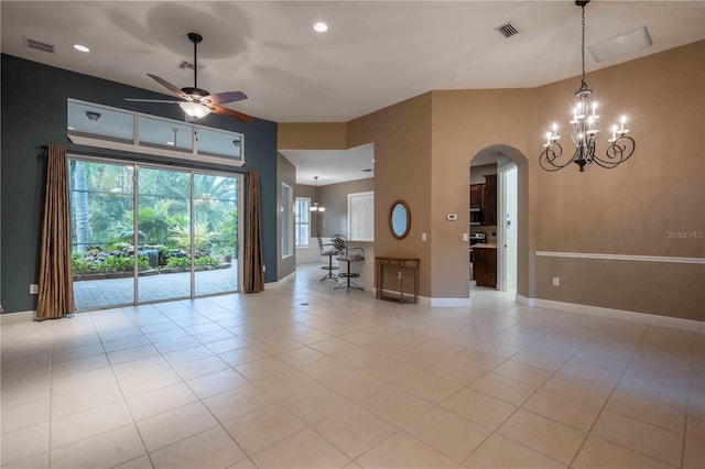 tiled spare room with ceiling fan with notable chandelier