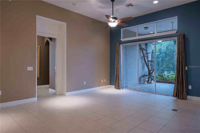 tiled spare room featuring ceiling fan