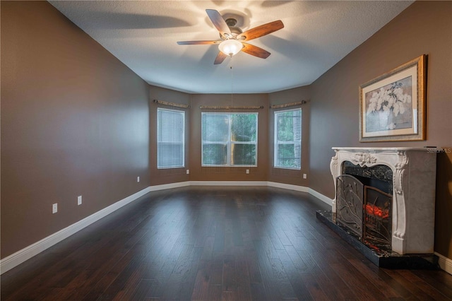 unfurnished living room featuring a premium fireplace, dark hardwood / wood-style floors, a textured ceiling, and ceiling fan