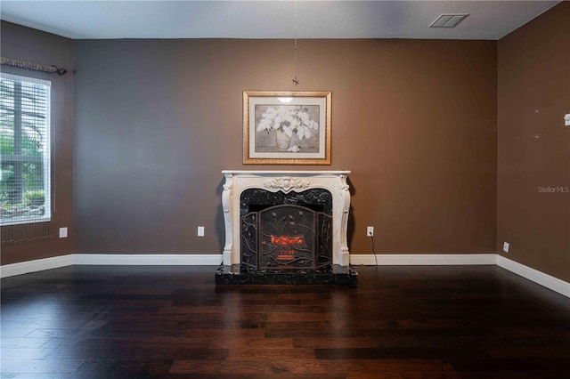 unfurnished living room with a high end fireplace and dark hardwood / wood-style floors