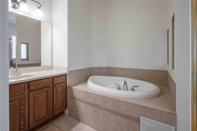 bathroom with a relaxing tiled tub, tile patterned floors, and vanity