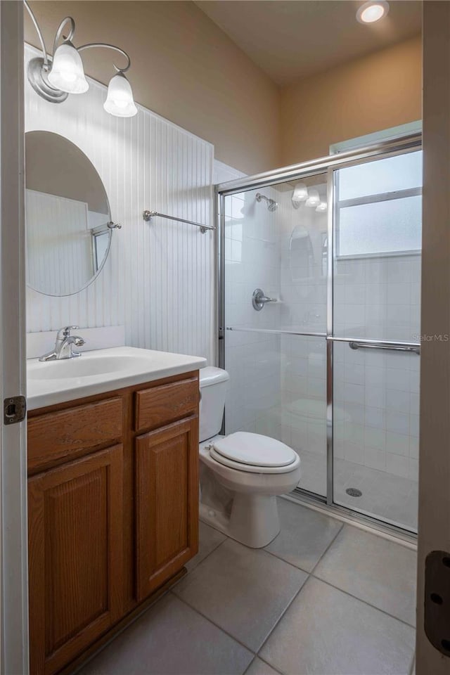 bathroom with vanity, toilet, tile patterned floors, and walk in shower