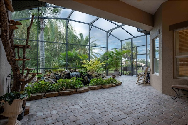 view of patio featuring glass enclosure