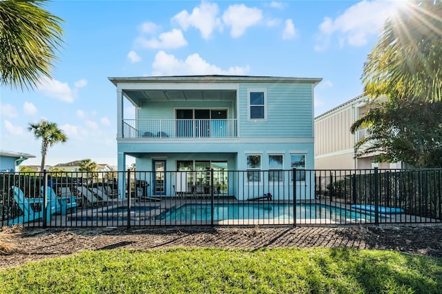 rear view of house with a balcony, a fenced in pool, and a patio area