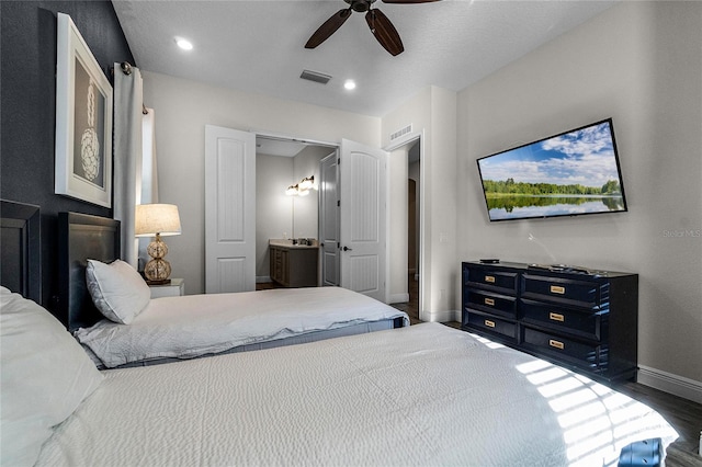 bedroom featuring ceiling fan, dark wood-type flooring, and connected bathroom