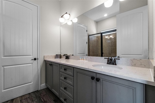 bathroom featuring hardwood / wood-style floors, vanity, and an enclosed shower