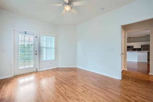 unfurnished room with light wood-type flooring and ceiling fan