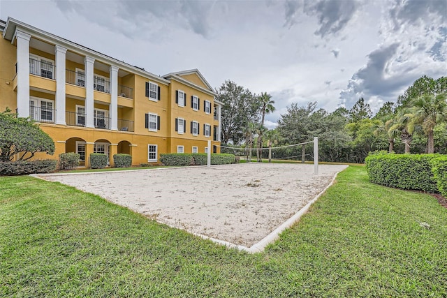 view of property's community featuring volleyball court and a lawn