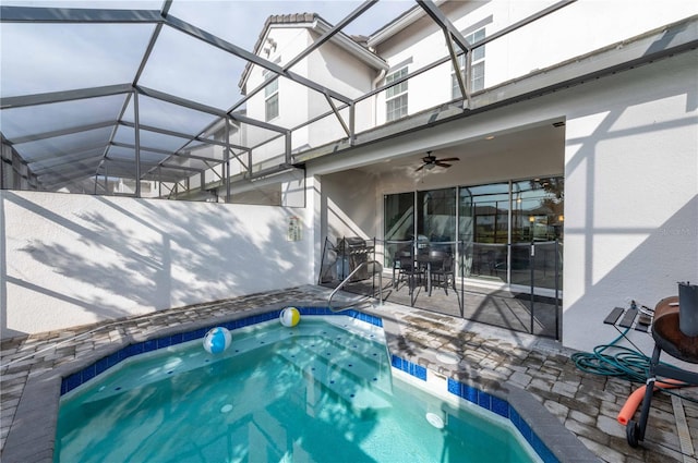 view of swimming pool with a patio area, ceiling fan, and glass enclosure