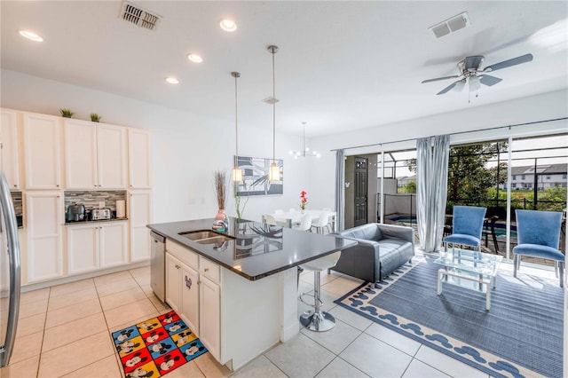 kitchen with white cabinetry, a kitchen island with sink, pendant lighting, and appliances with stainless steel finishes