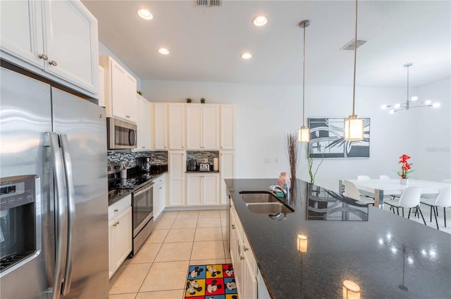 kitchen featuring decorative light fixtures, stainless steel appliances, white cabinetry, and sink