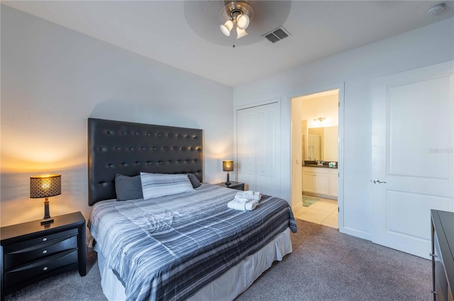 carpeted bedroom featuring ceiling fan, a closet, and ensuite bathroom