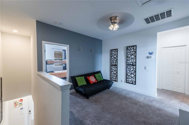 living area with ceiling fan and carpet