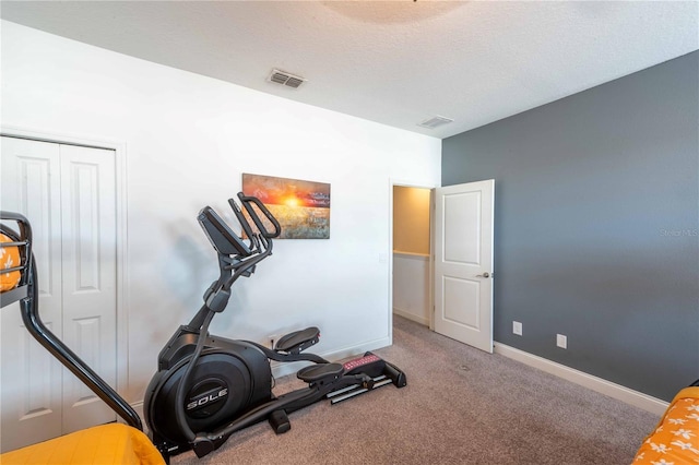 workout area featuring carpet floors and a textured ceiling