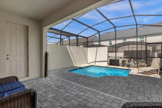 view of swimming pool with glass enclosure and a patio