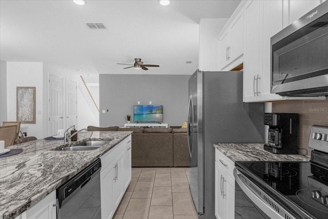 kitchen featuring light stone counters, stainless steel appliances, white cabinets, and sink