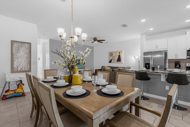 dining area with ceiling fan with notable chandelier and light tile patterned floors