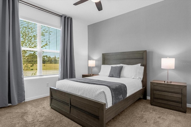 bedroom with ceiling fan, light carpet, and multiple windows