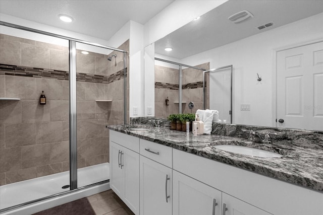 bathroom with tile patterned floors, vanity, and a shower with shower door