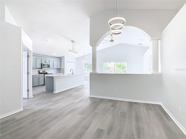 unfurnished living room featuring high vaulted ceiling, ceiling fan, wood-type flooring, and sink