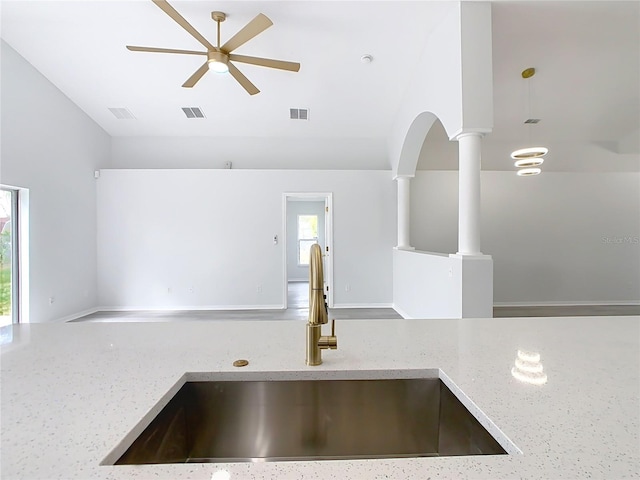 details featuring light stone countertops, ceiling fan, ornate columns, and sink