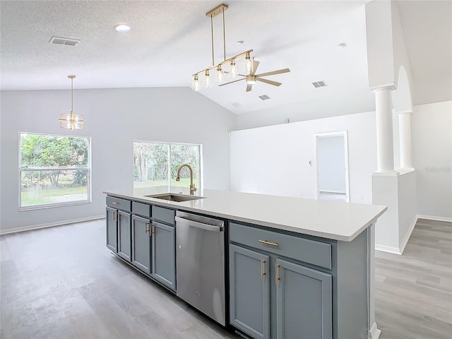 kitchen featuring dishwasher, lofted ceiling, sink, decorative columns, and a center island with sink