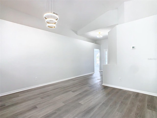 unfurnished room with dark hardwood / wood-style flooring and vaulted ceiling