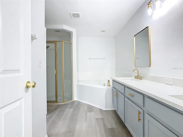 bathroom featuring hardwood / wood-style floors, vanity, and shower with separate bathtub