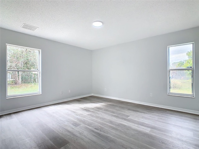 unfurnished room featuring hardwood / wood-style floors and a textured ceiling