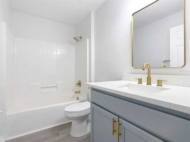 full bathroom with hardwood / wood-style floors, toilet, vanity, and shower / washtub combination