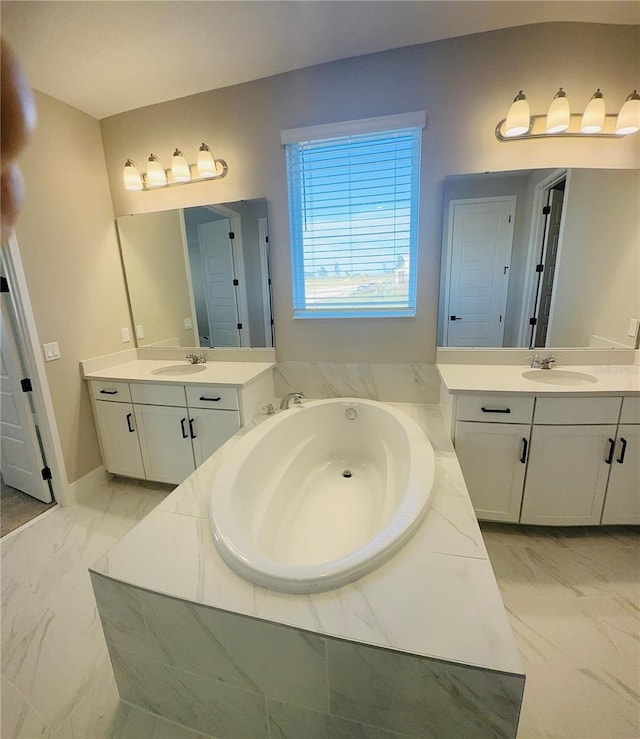 bathroom with a relaxing tiled tub and vanity