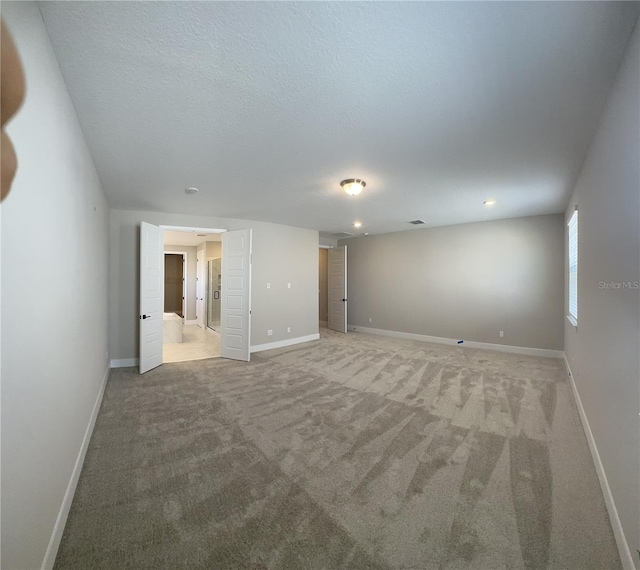 carpeted spare room with a textured ceiling