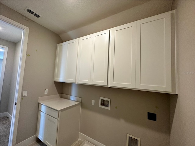 washroom with hookup for a washing machine and cabinets