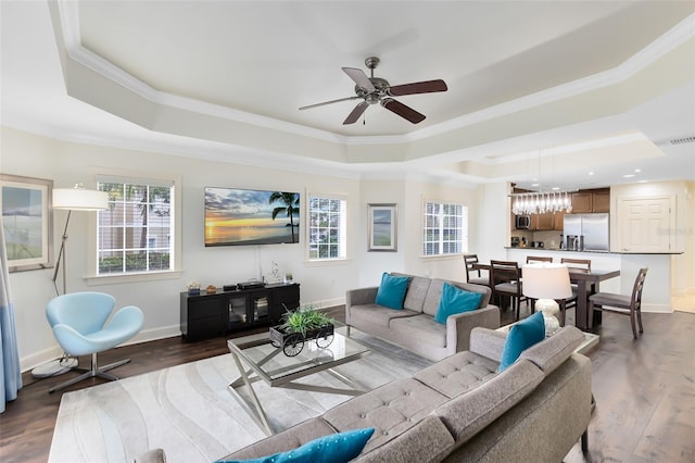 living room with crown molding, dark hardwood / wood-style flooring, and a raised ceiling