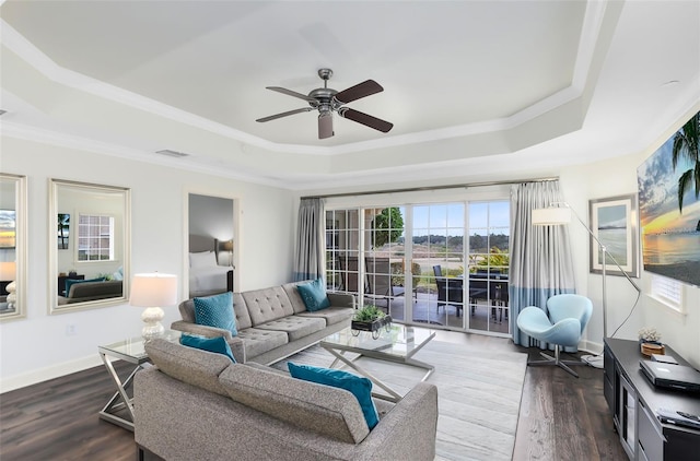 living room with ornamental molding, dark hardwood / wood-style floors, ceiling fan, and a raised ceiling