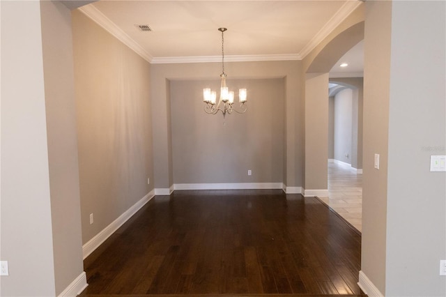 unfurnished dining area featuring dark hardwood / wood-style floors, ornamental molding, and a chandelier