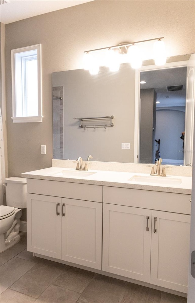 bathroom featuring toilet, tile patterned floors, and vanity