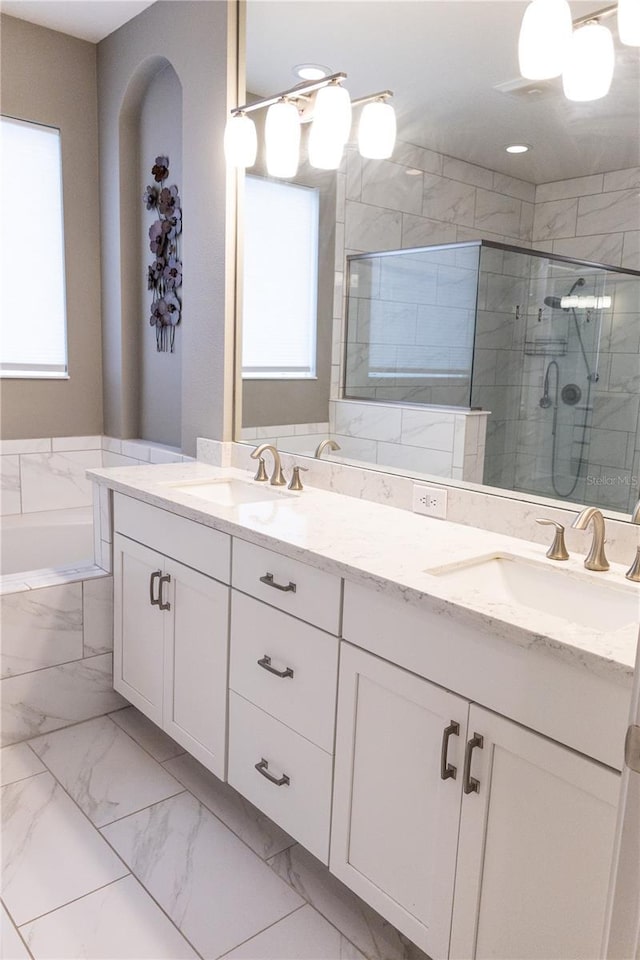 bathroom featuring vanity and shower with separate bathtub