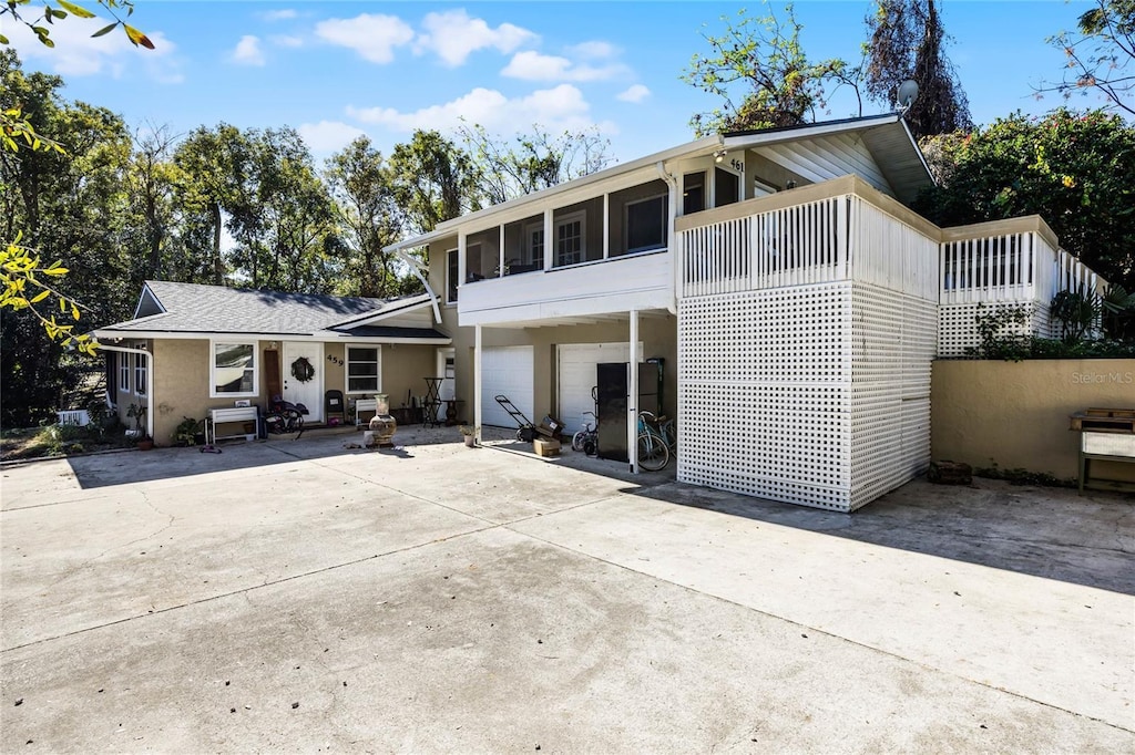 rear view of property with a garage and a sunroom