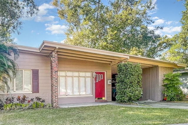 entrance to property featuring a carport and a lawn