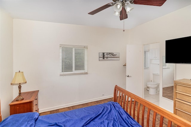 tiled bedroom featuring ensuite bathroom and ceiling fan