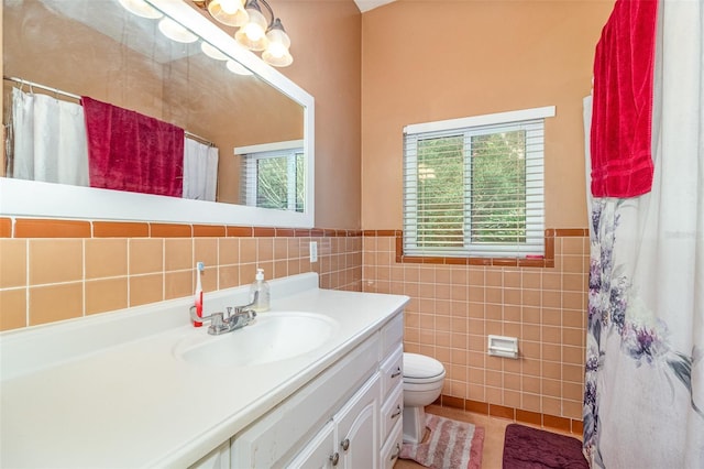 bathroom with tile walls, a shower with shower curtain, a wealth of natural light, and vanity