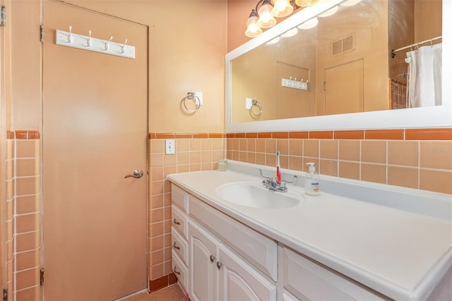 bathroom with tile walls, a shower with shower curtain, and vanity