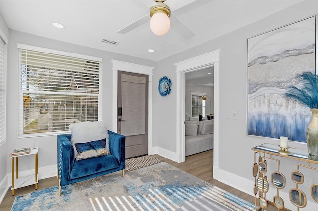 sitting room with ceiling fan and light hardwood / wood-style flooring