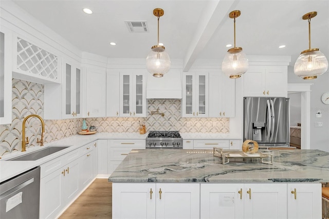 kitchen featuring sink, an island with sink, hanging light fixtures, and appliances with stainless steel finishes