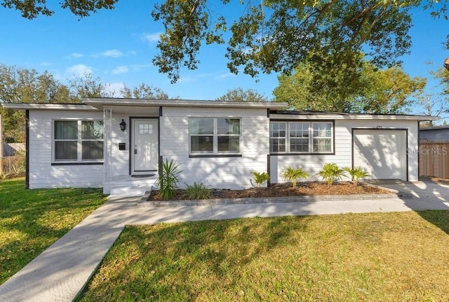 single story home featuring a garage and a front lawn