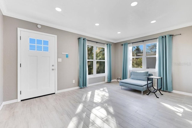 entrance foyer featuring ornamental molding and light wood-type flooring