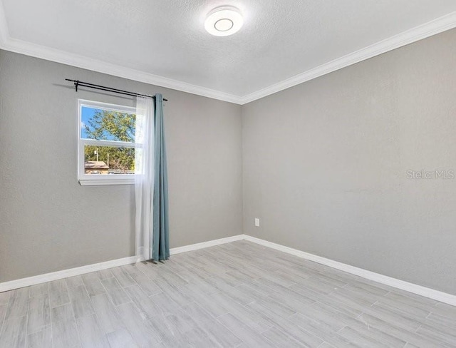 empty room with ornamental molding and a textured ceiling