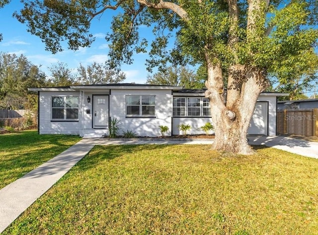 ranch-style house featuring a garage and a front lawn